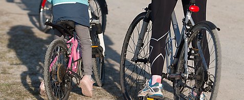 På bild cyklar två personer. På bild syns två cyklar och personernas rygg. 